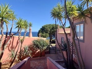 Enjoy breathtaking sea views from the comfort of this serene property, surrounded by a well-maintained garden and a paved walkway.