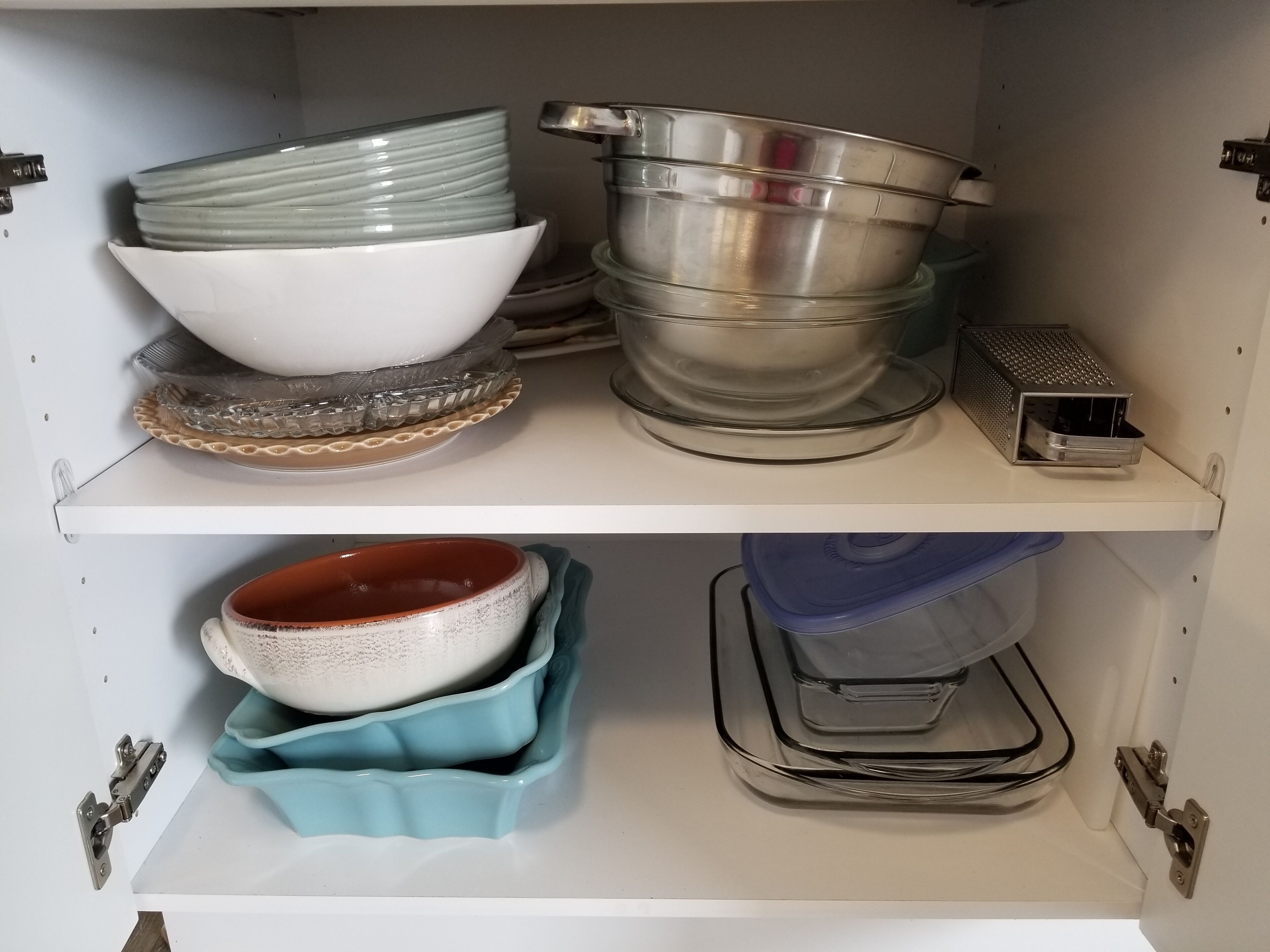 Un armario de cocina con estantes que contienen distintos utensilios de cocina.