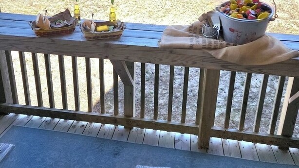 Une terrasse en bois offrant une vue sur la plage et l’océan.