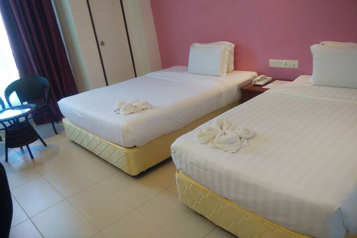 A hotel room with two beds, a desk, and a chair.