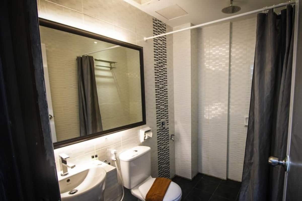 A modern bathroom with a toilet, sink, and shower.