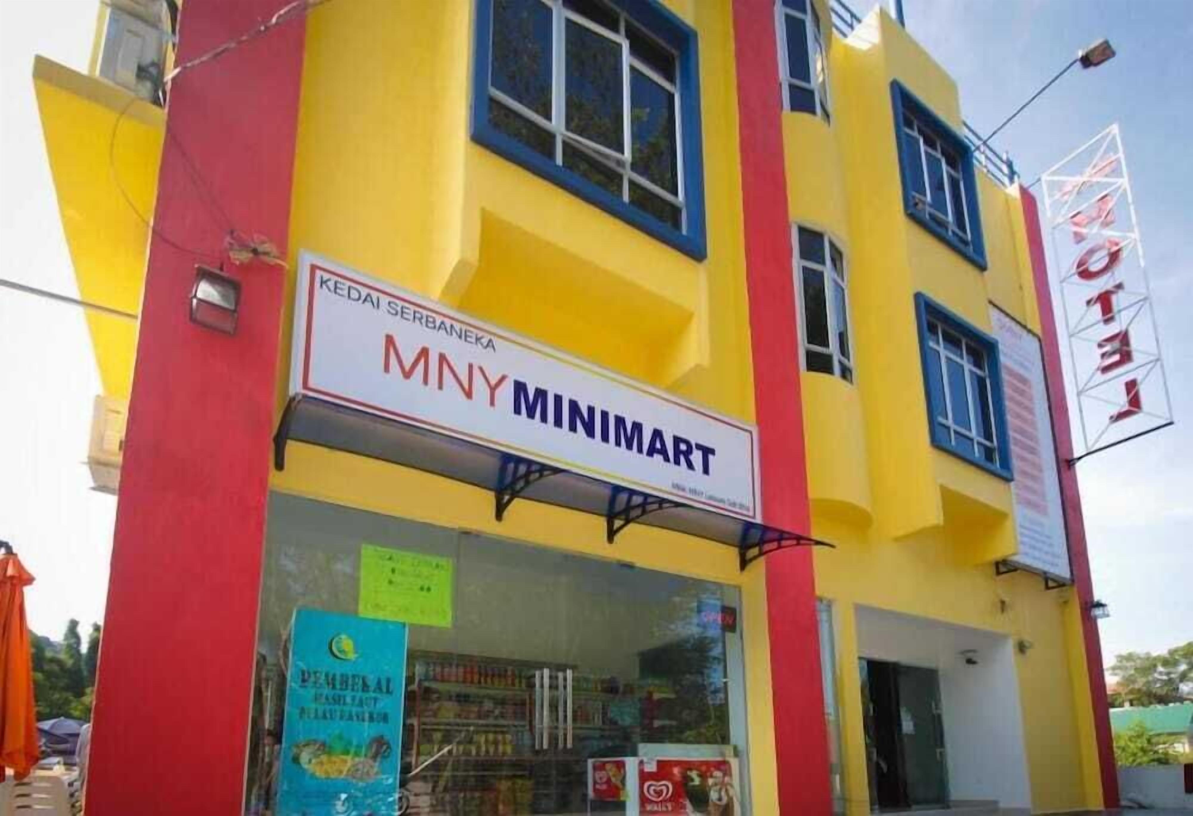 A building with a Minimart sign, a hotel sign, and a sign for a local business.