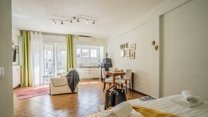A hotel room with a bed, a desk, a chair, a small table, and a window. - Conte Rosso Apartments ARCA (Mestre)