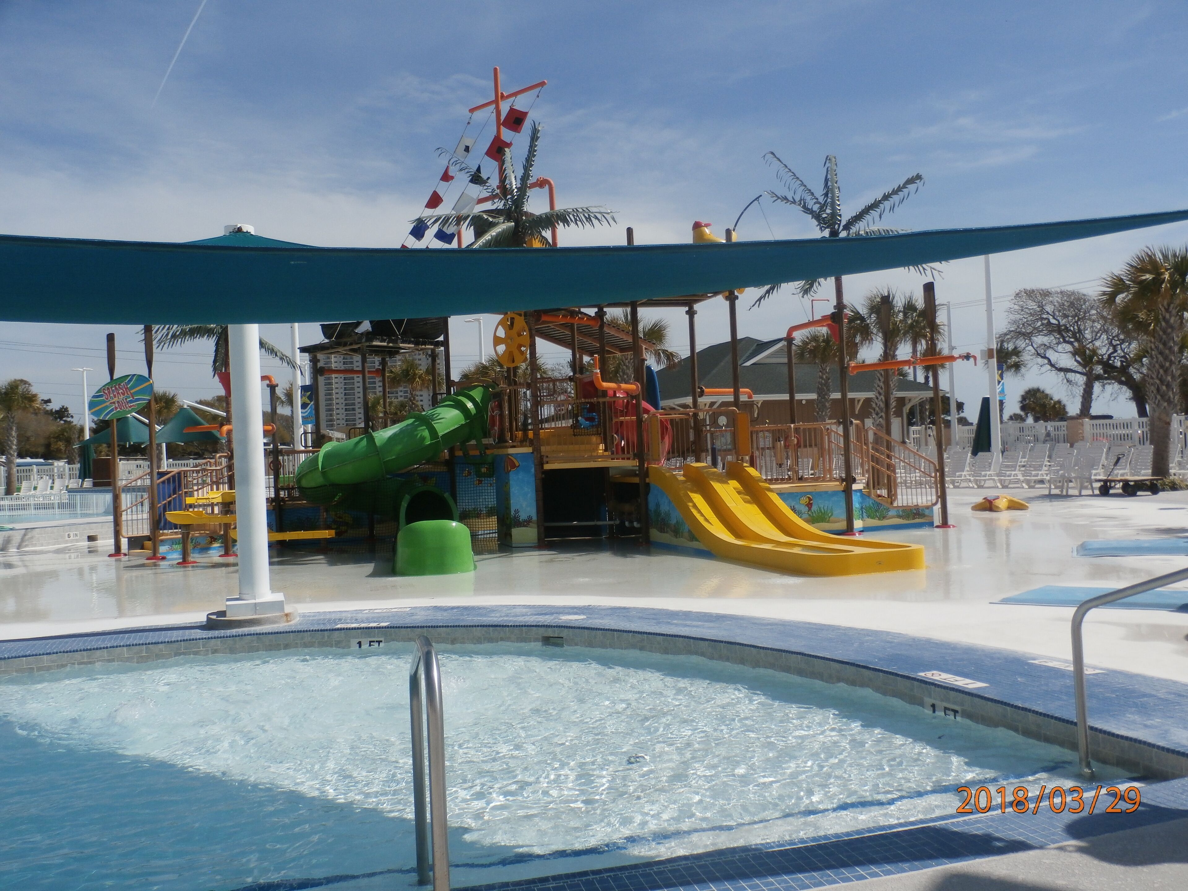 Un parc aquatique avec une piscine, des toboggans et des aires de jeux.