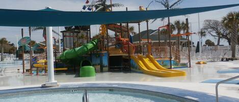 Un parc aquatique avec une piscine, des toboggans et des aires de jeux.