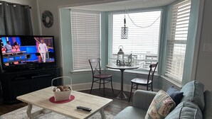 A living room with a television, a table with a basket, and a sofa. -  Ocean Lakes / Oceanfront /   5 bed/ water park /slps 14 (myrtle beach)