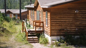 A wooden cabin with a porch and steps leading to a door. - Ponderosa Cabin with Private Hot Tub - Near Mt Rushmore and Hills Attractions (Custer)