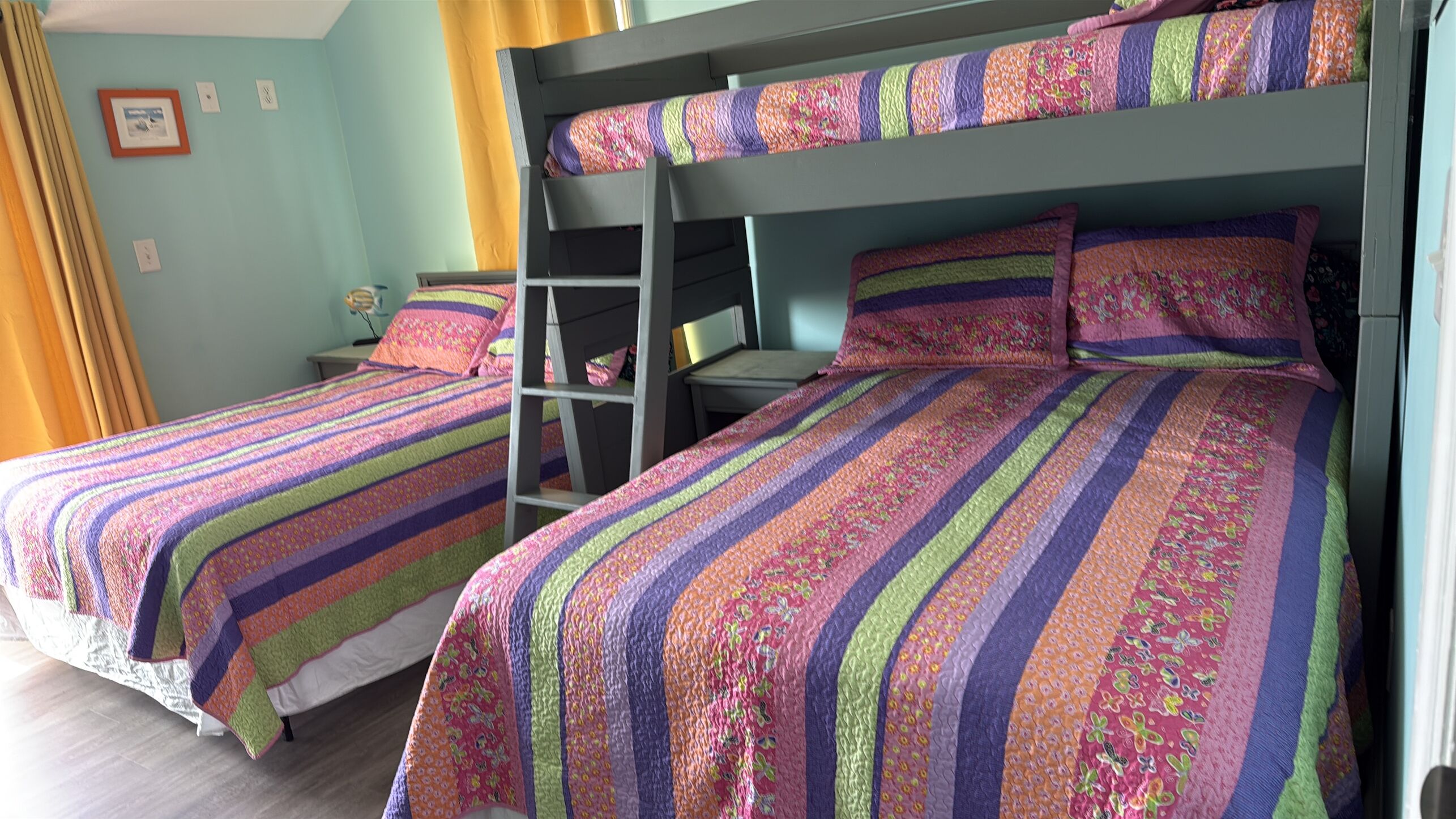 A room with bunk beds, a desk, and a chair.
