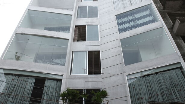 Un immeuble moderne et imposant, doté de nombreux étages et de grandes fenêtres.
