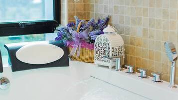 A bathroom with a bathtub, a window, and a shower.