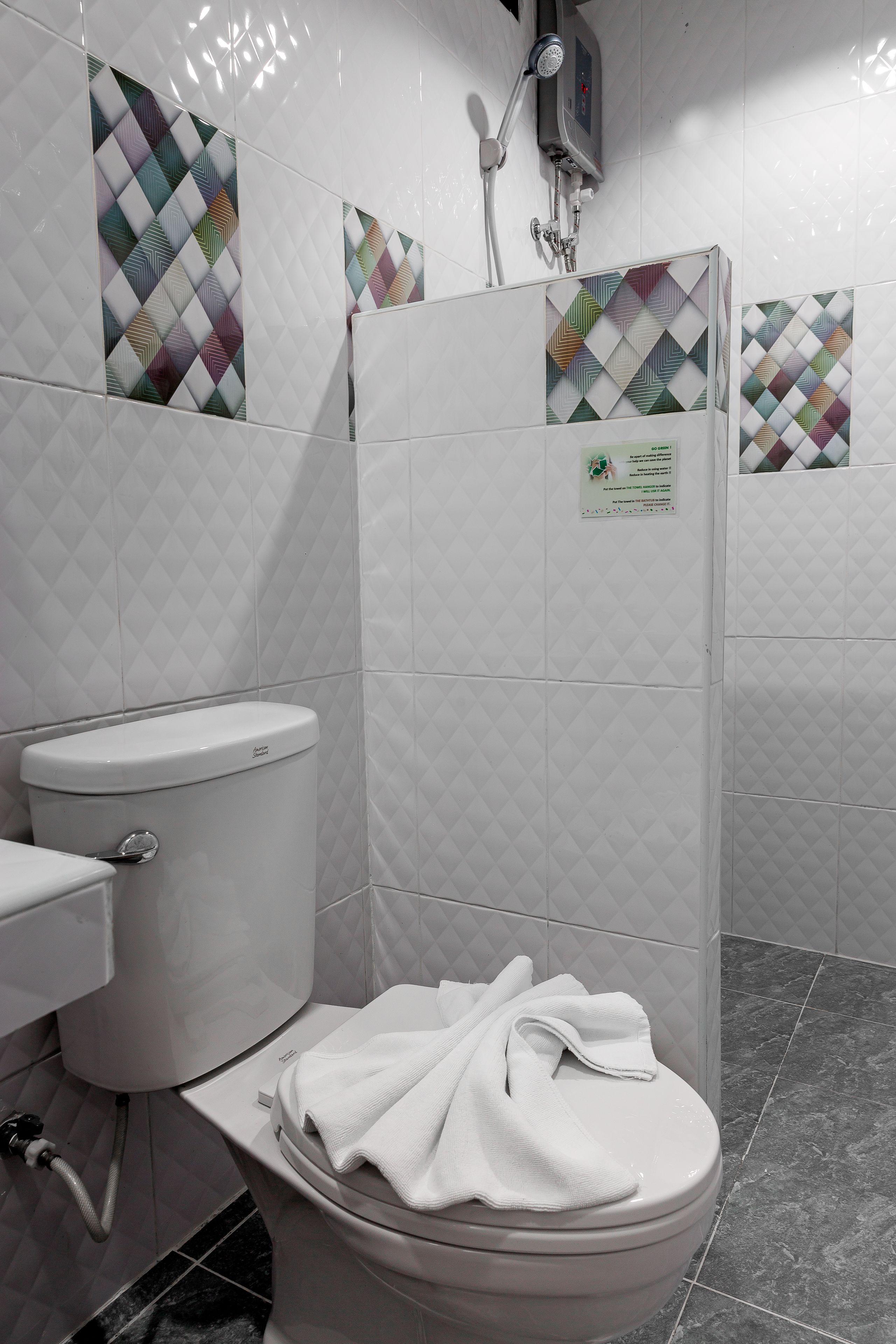 A bathroom with a toilet, a shower, and a sink.
