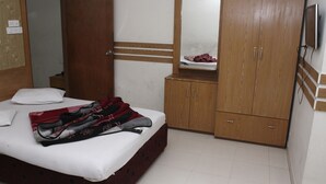 A bedroom with a bed, a wardrobe, a mirror, and a television. - White Beach Hotel (Cox's Bazar)