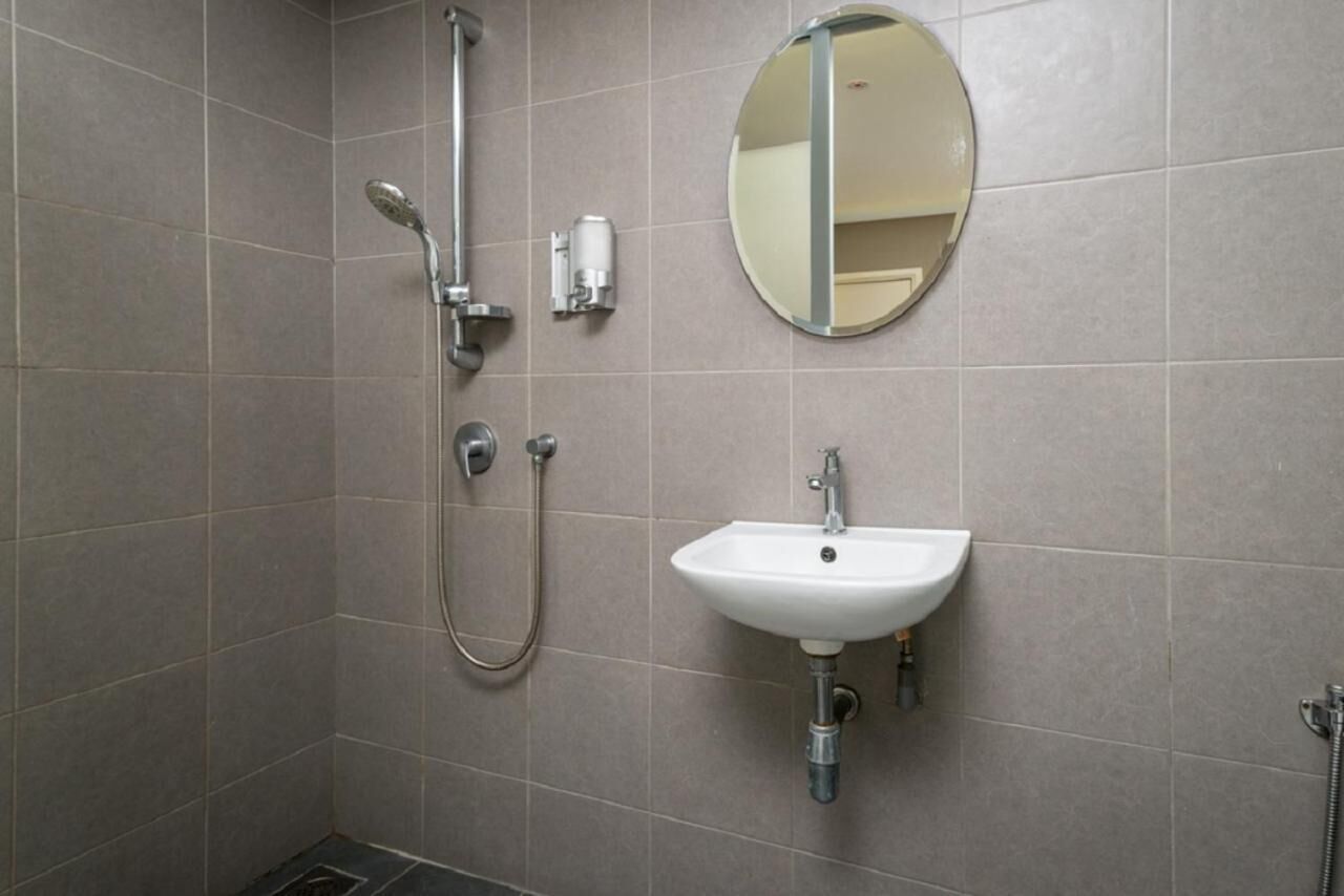 A bathroom with a shower, a sink, and a mirror.