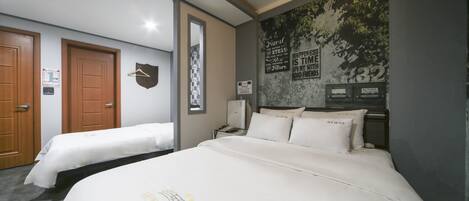 A hotel room with two beds, a coat rack, a nightstand, and a wall with a nature-themed mural.