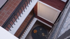 Esquina de una habitación con una puerta blanca, una puerta negra y un suelo de baldosas.