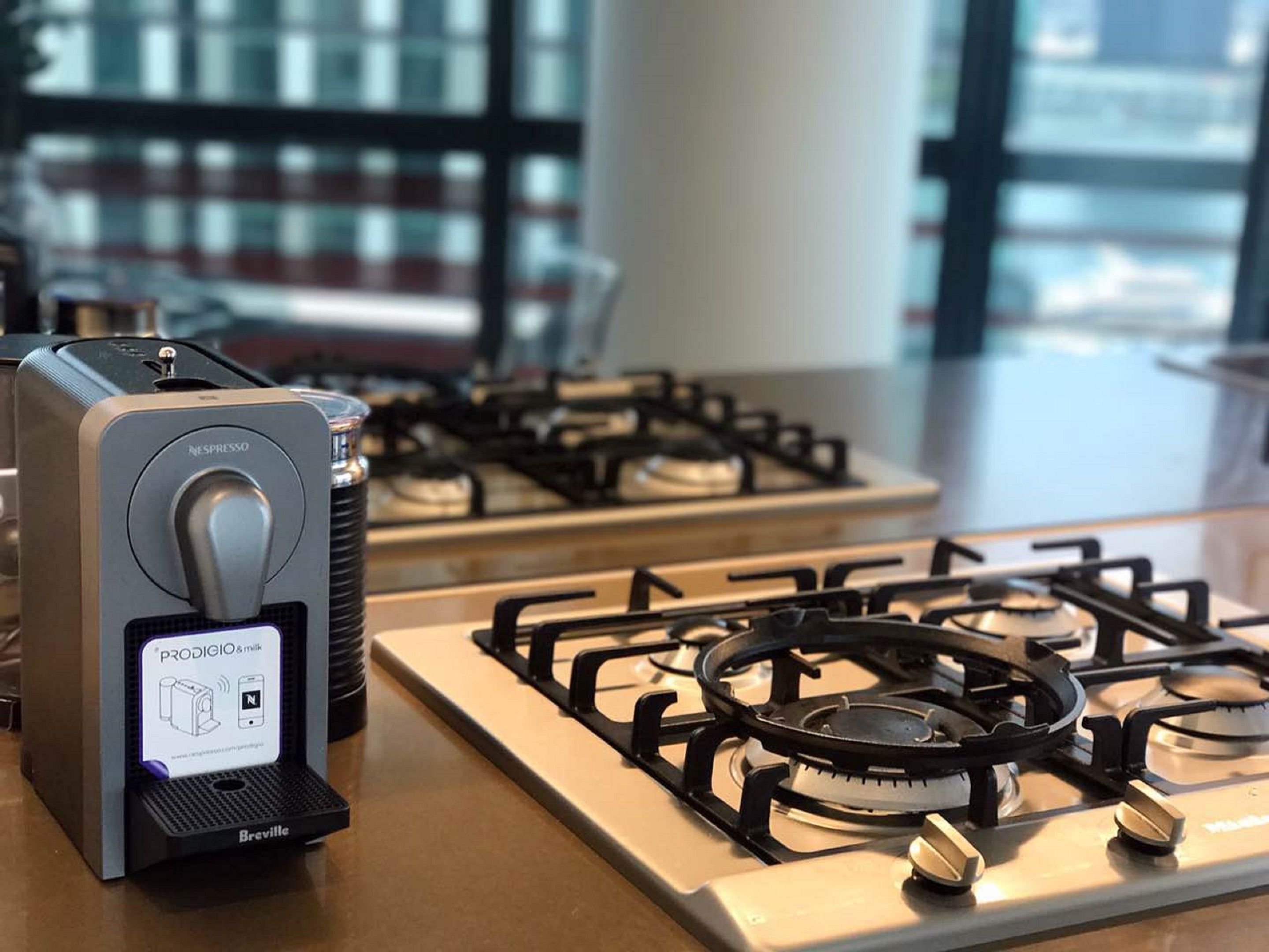 Une cuisine équipée d’une plaque de cuisson à induction Breville et d’une machine à café Nespresso.