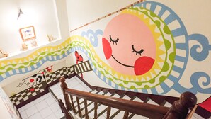Un escalier avec une rampe en bois et une fresque colorée sur le mur.