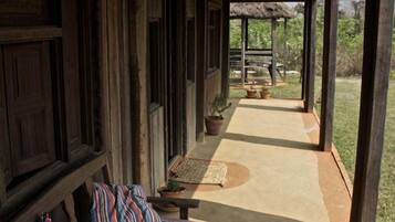 A covered outdoor seating area with benches and a thatched roof structure.