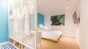 Une chambre moderne équipée d’un lit, d’un bureau et d’un espace douche.