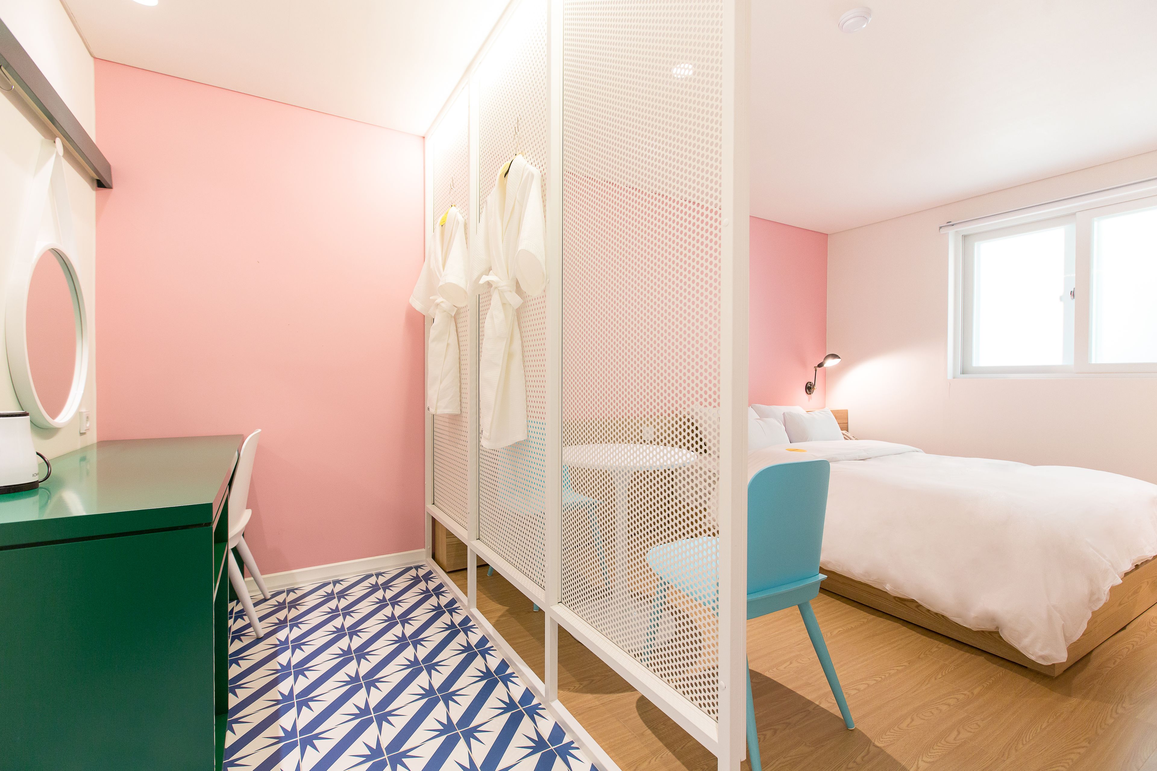 A bedroom with a bed, a desk, a chair, and a wardrobe.