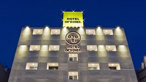 Un hôtel à plusieurs étages, doté d’une façade moderne, d’une enseigne lumineuse et d’un logo bien visible.