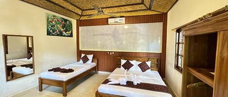 A hotel room with two beds, a ceiling fan, a large mirror, and a painting of koi fish.