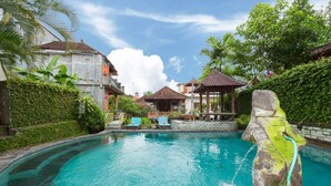 A swimming pool with lounge chairs, a gazebo, and lush greenery. - Sayong House (Ubud)