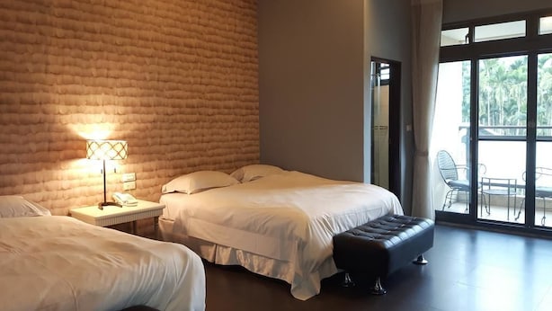 A hotel room with two beds, a large window, and a brick wall. - Lins Ju Homestay (Yuchi)