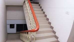 A staircase with beige steps and a red handrail. - Hillside Holiday Home (Sylhet)