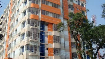 A multi-story building with a modern architectural design, featuring balconies and large windows.