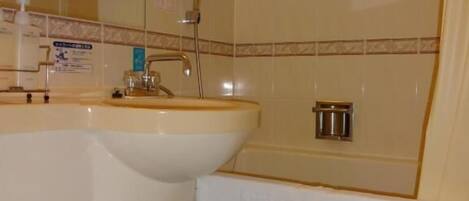 Un baño con inodoro, lavamanos y ducha.