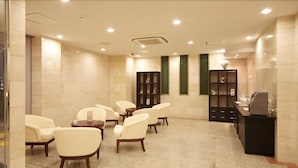Una habitación de hotel con zona de estar, mostrador de recepción y minibar.