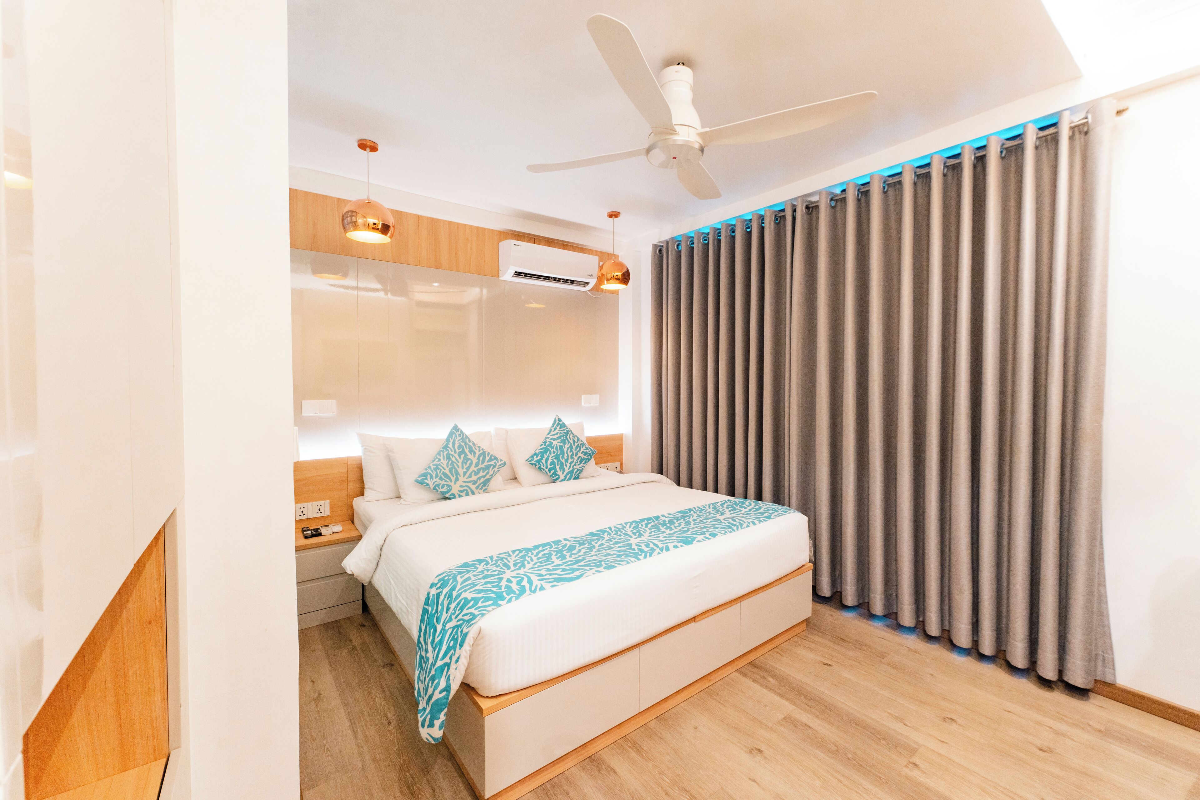 A modern bedroom with a bed, nightstand, and built-in air conditioning unit.