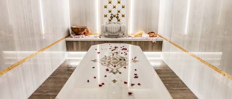 A luxurious bathroom with a marble vanity, a large mirror, and a decorative wall panel.