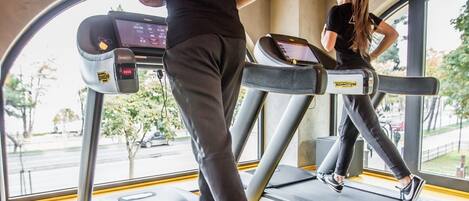 A gym with treadmills and a large window.