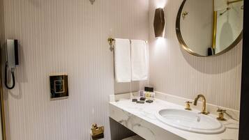 A modern bathroom with two sinks, a toilet, and a shower.