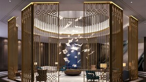 A modern lobby with a central seating area, a decorative wall with hanging elements, and a staircase. - PRIMUS Hotel Wuhan Hannan (Wuhan)