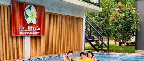 Una piscina con cubierta de madera y un letrero que indica Leelawadee Resort.