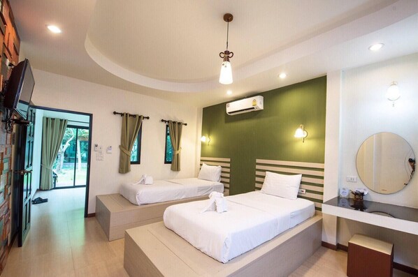 A hotel room with two beds, a large mirror, a TV, and an air conditioning unit. - Baansuan Leelawadee Resort Nan (Nan)