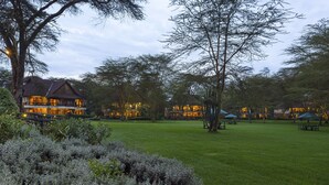 A large, well-lit building with multiple balconies and a spacious lawn area. - Sawela Lodge (Naivasha)