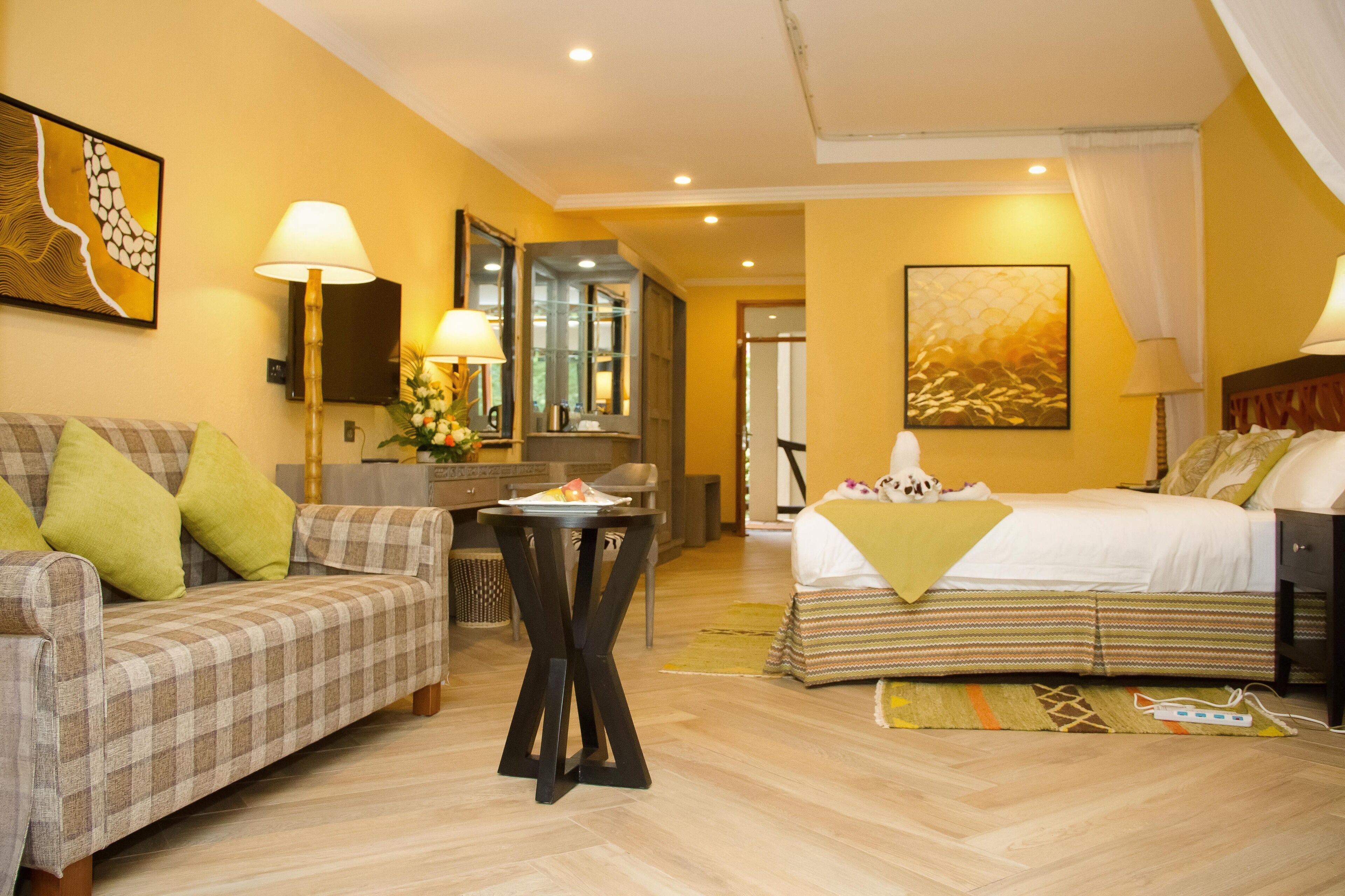 Een hotelkamer met een bed, een bank, een tafeltje en een spiegel.