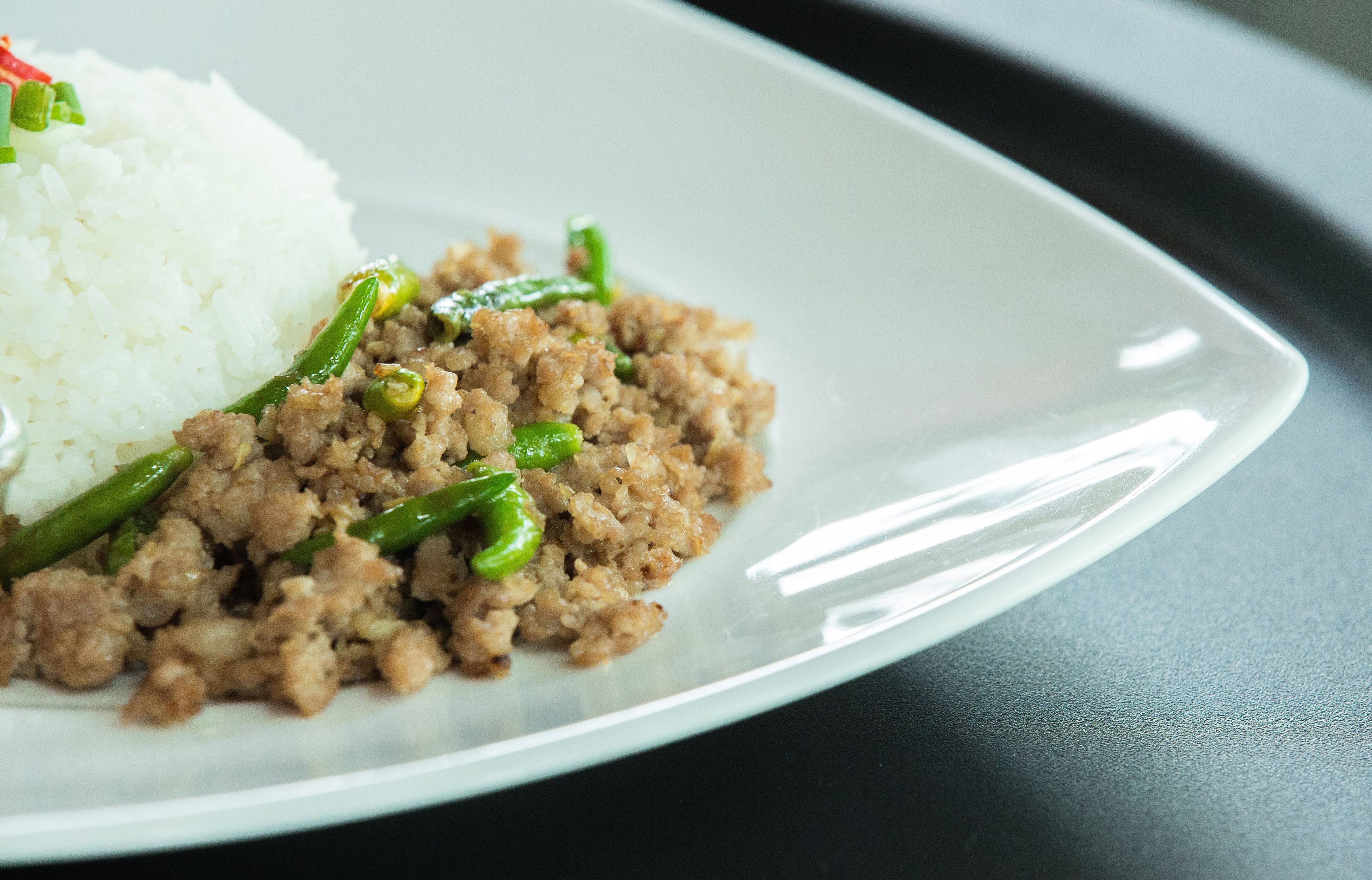Un plato de carne picada con judías verdes y arroz blanco.