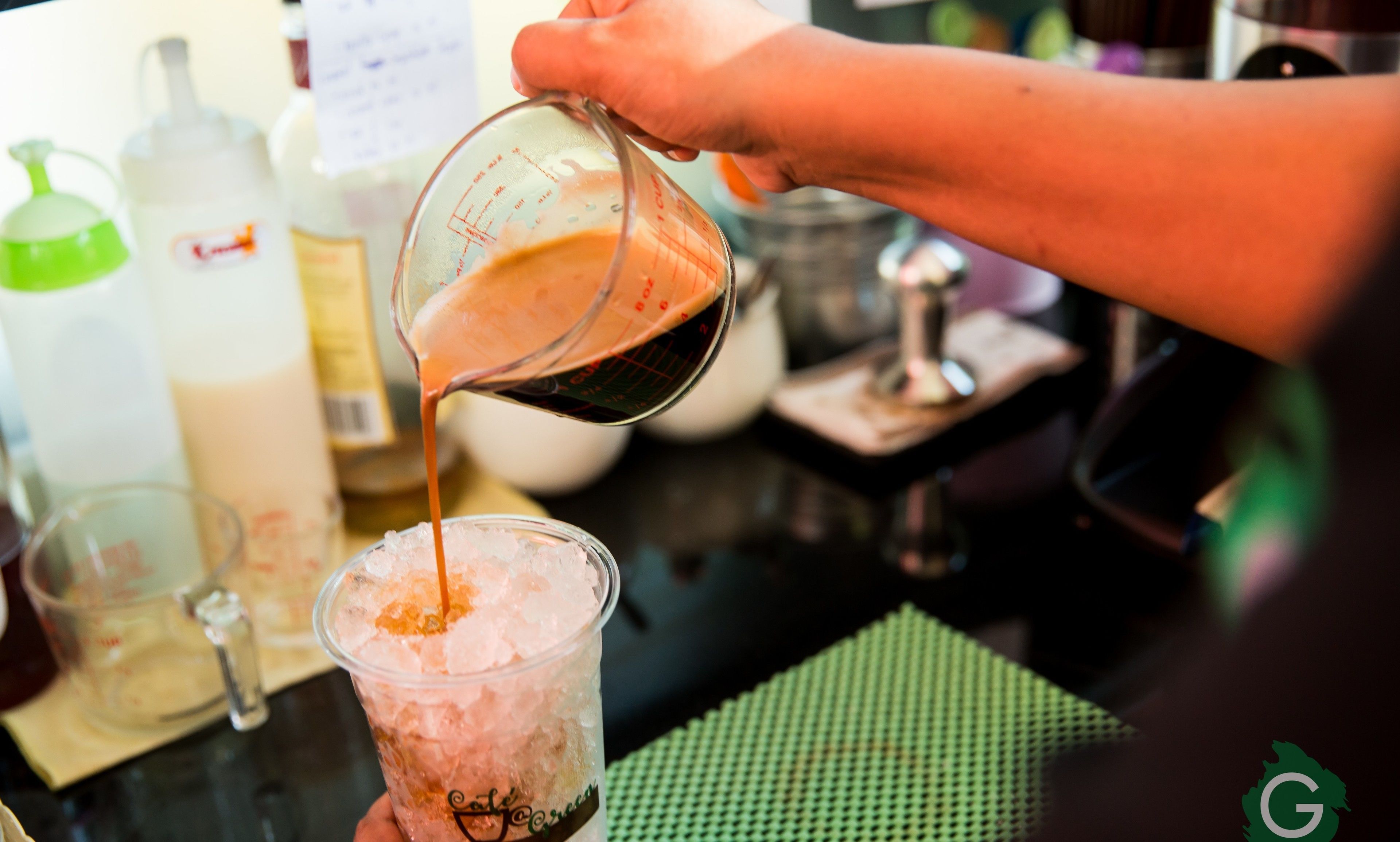 Una persona sirve una bebida en un vaso con hielo.