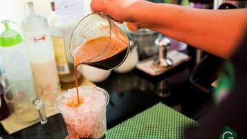 Una persona sirve una bebida en un vaso con hielo.
