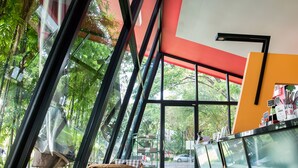 Un interior moderno con ventanas amplias, una silla de mimbre y una zona de bar.