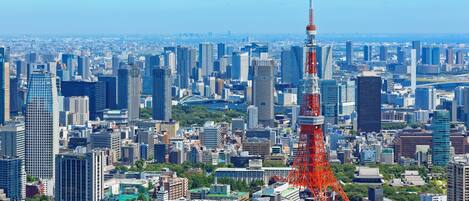 A cityscape with a prominent red tower, dense urban buildings, and a mix of modern and traditional architecture.