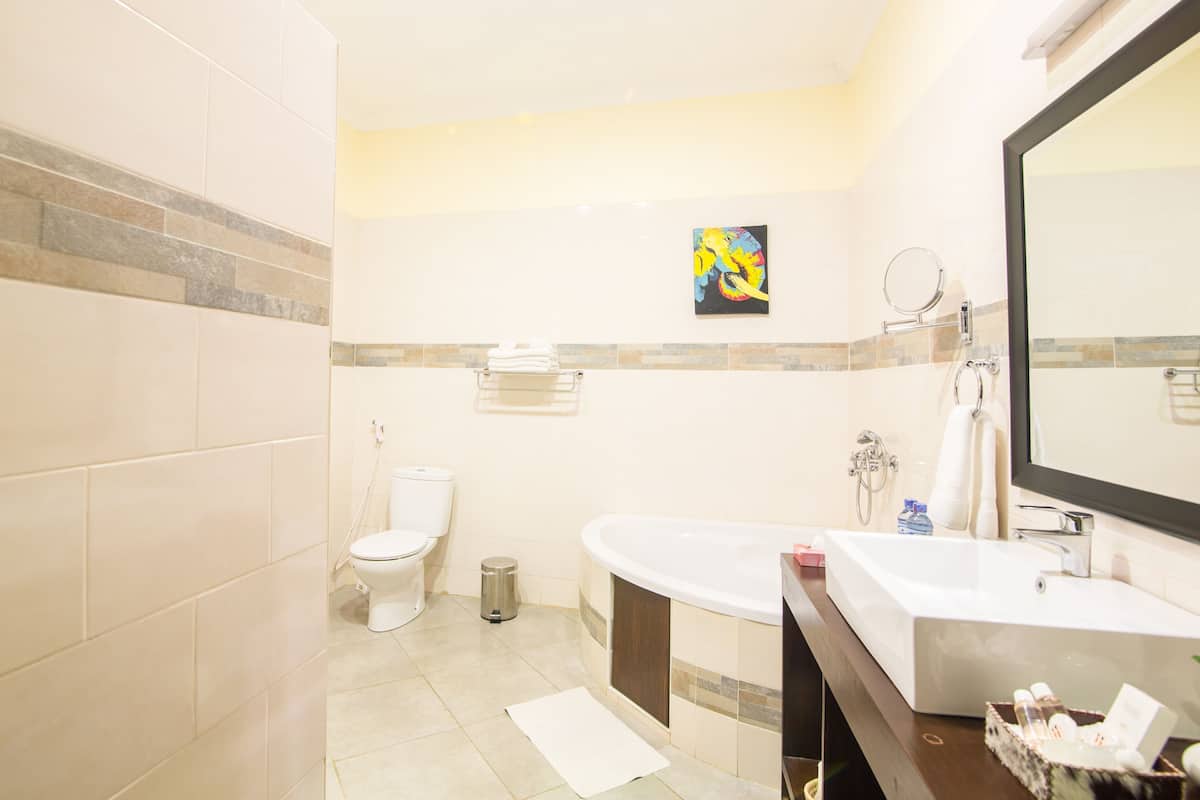 Un baño con inodoro, lavamanos, bañera y espejo.