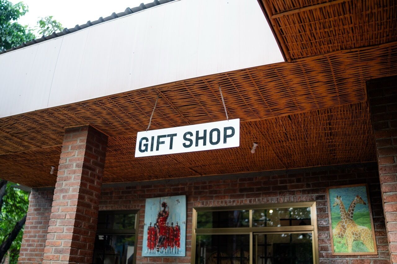 Un bâtiment en briques avec une enseigne indiquant « MAGASIN DE CADEAUX » au-dessus de l’entrée.