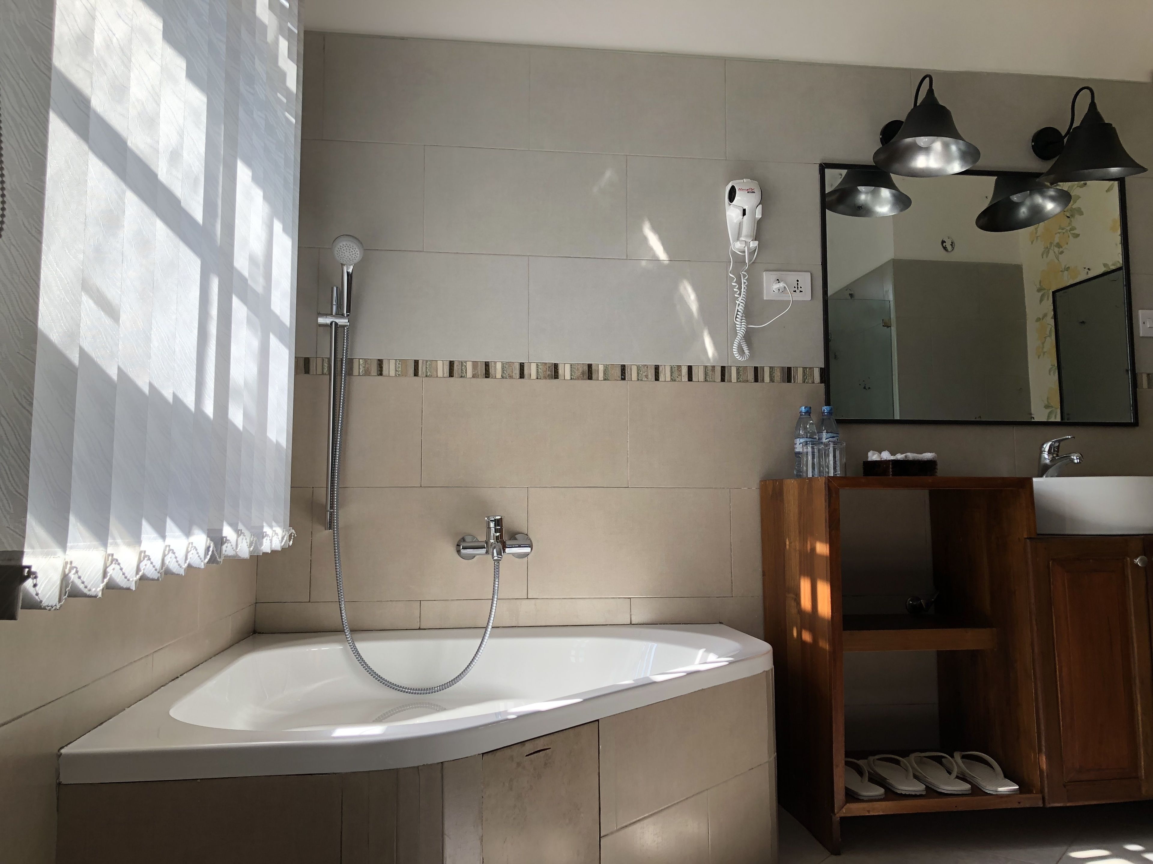 A bathroom with a bathtub, a shower, a sink, and a mirror.