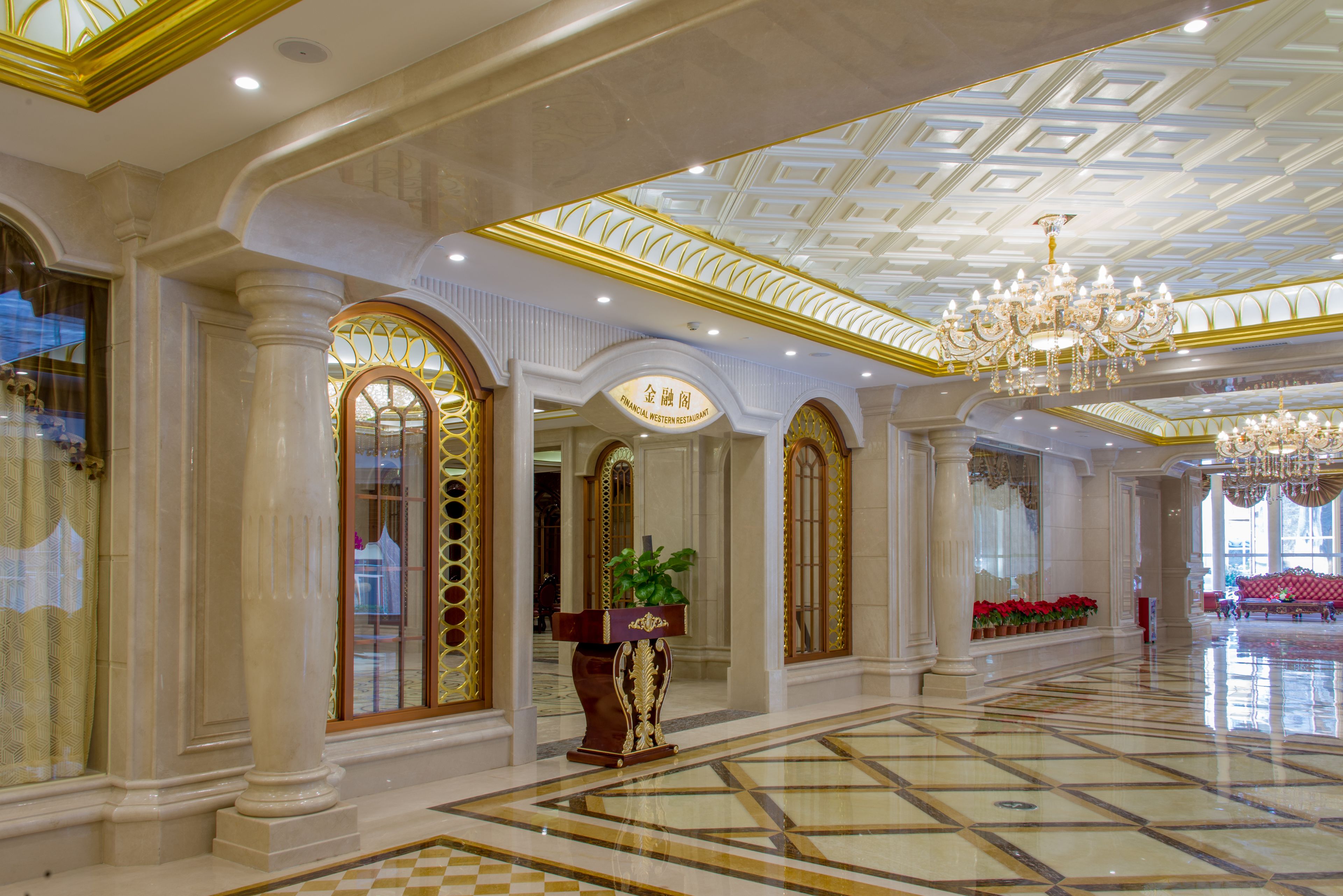 A luxurious lobby with a checkered floor, ornate columns, and a grand chandelier.